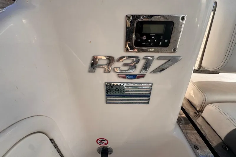Slide: The Image of 2021 Robalo R317 Dual Console boat interior with control panel and emblem. - 20