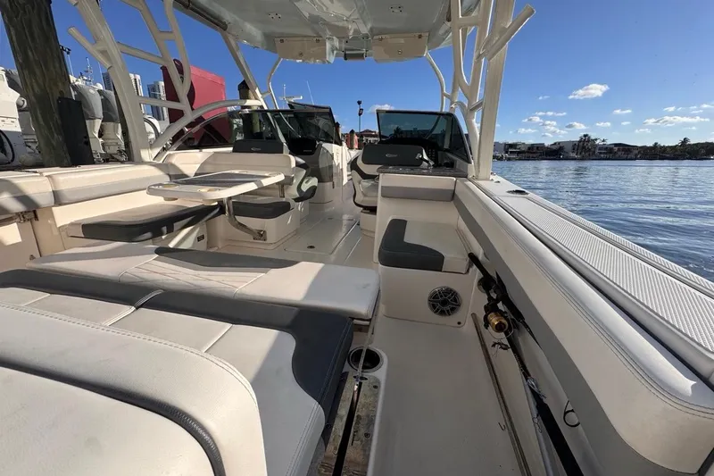 Slide: The Image of 2021 Robalo R317 Dual Console boat interior with seating and table, docked by the water. - 25