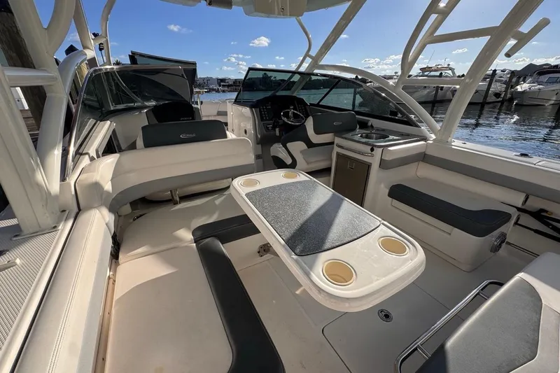 Slide: The Image of 2021 Robalo R317 Dual Console boat interior with seating and table, docked at marina. - 26