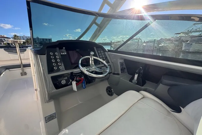 Slide: The Image of 2021 Robalo R317 Dual Console boat cockpit with steering wheel and controls. - 31