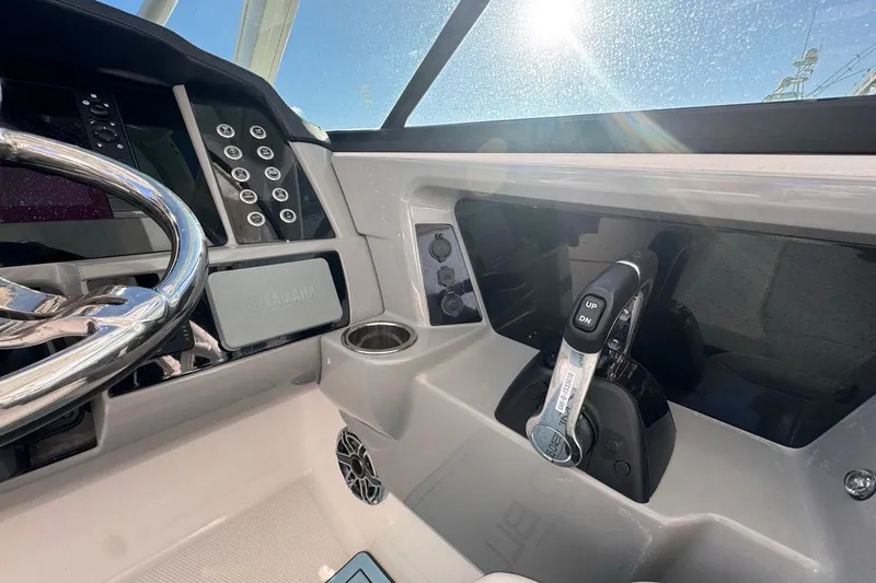 Slide: The Image of 2021 Robalo R317 Dual Console helm with steering wheel and controls in sunlight. - 32