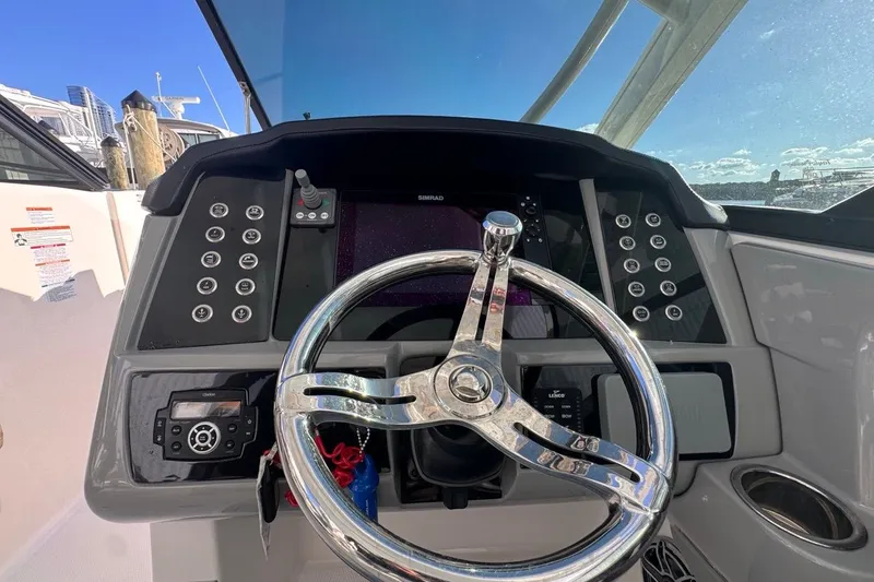 Slide: The Image of 2021 Robalo R317 Dual Console helm with modern controls and steering wheel. - 33