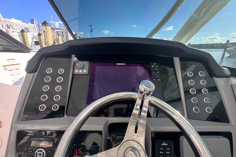 Slide: The Image of 2021 Robalo R317 Dual Console helm with steering wheel and navigation controls. - 34