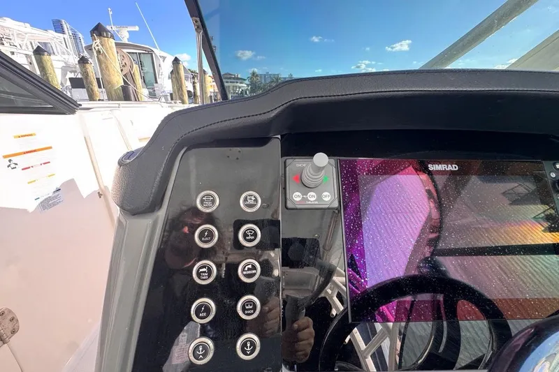 Slide: The Image of 2021 Robalo R317 Dual Console dashboard with Simrad display and control buttons. - 35