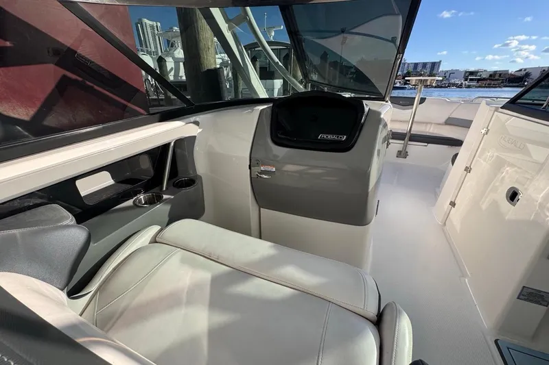 Slide: The Image of 2021 Robalo R317 Dual Console interior with seating and helm, docked by the waterfront. - 36