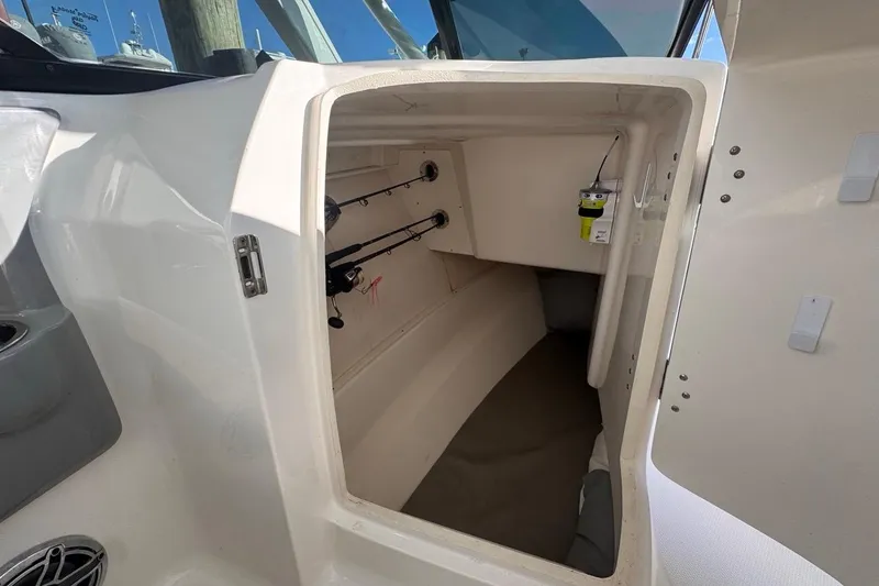Slide: The Image of 2021 Robalo R317 Dual Console cabin interior with fishing rod storage. - 39