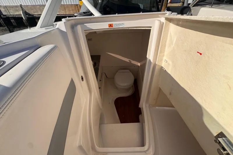 Slide: The Image of 2021 Robalo R317 Dual Console boat interior with compact marine toilet. - 51
