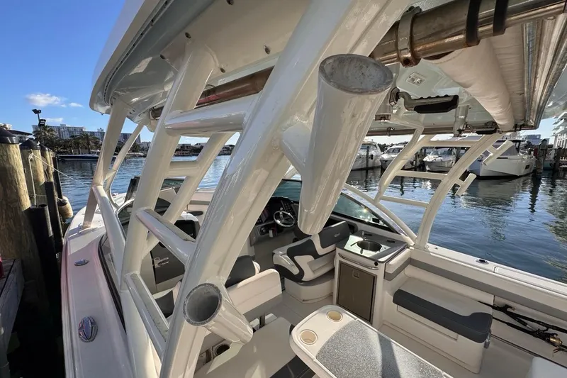 Slide: The Image of 2021 Robalo R317 Dual Console boat interior with seating and helm, docked by the water. - 57
