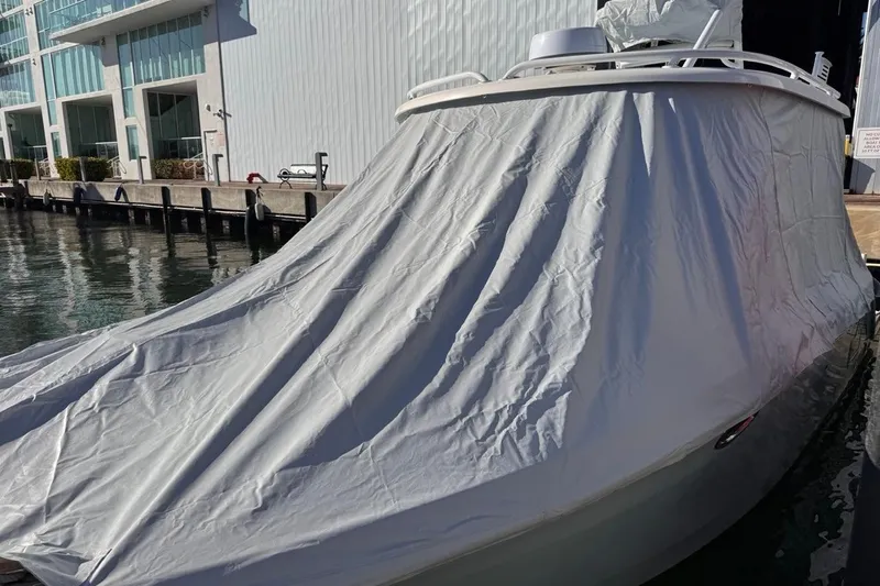 Slide: The Image of 2021 Robalo R317 Dual Console boat covered with tarp at marina dock. - 71