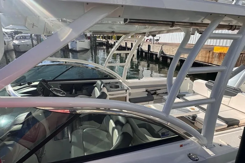 Slide: The Image of 2021 Robalo R317 Dual Console boat interior at marina, showcasing seating and helm. - 8