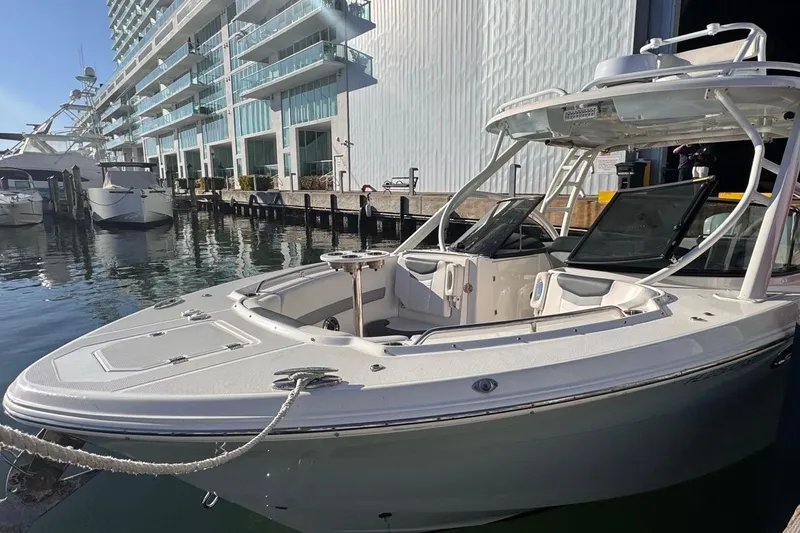 Slide: The Image of 2021 Robalo R317 Dual Console boat docked near modern waterfront buildings. - 9
