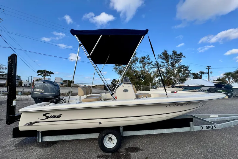 The Image of 2023 Scout 177 Sport boat on trailer with Yamaha engine, under blue sky. - 0