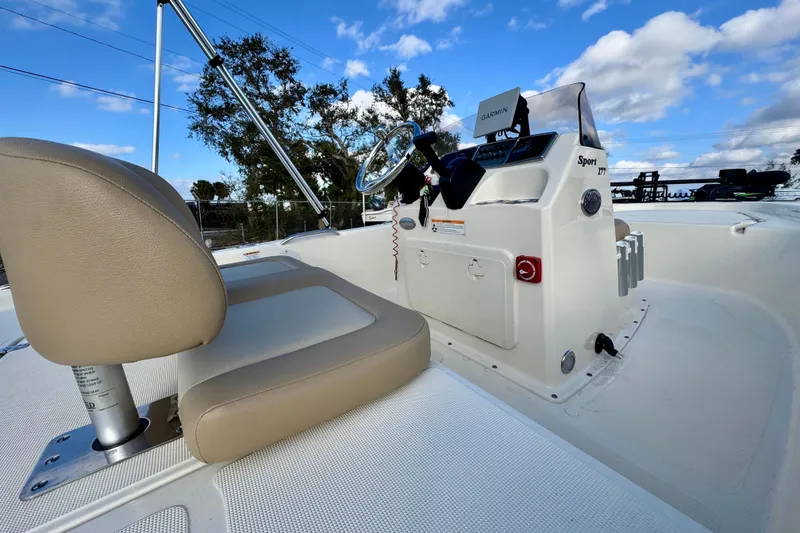 Slide: The Image of 2023 Scout 177 Sport boat interior with steering console and beige seating. - 15