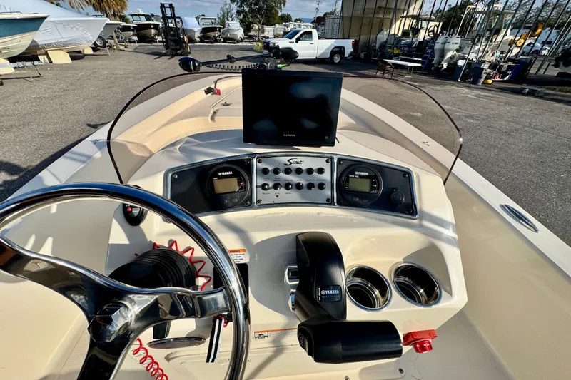 Slide: The Image of 2023 Scout 177 Sport boat dashboard with steering wheel and navigation controls. - 17
