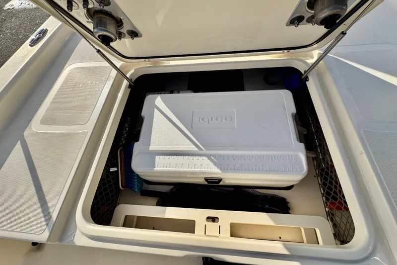 Slide: The Image of 2023 Scout 177 Sport boat storage compartment with Igloo cooler and accessories. - 19