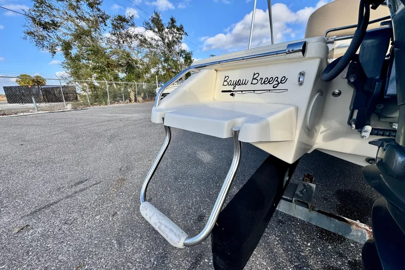 Slide: The Image of 2023 Scout 177 Sport boat with "Bayou Breeze" name, docked on asphalt. - 20