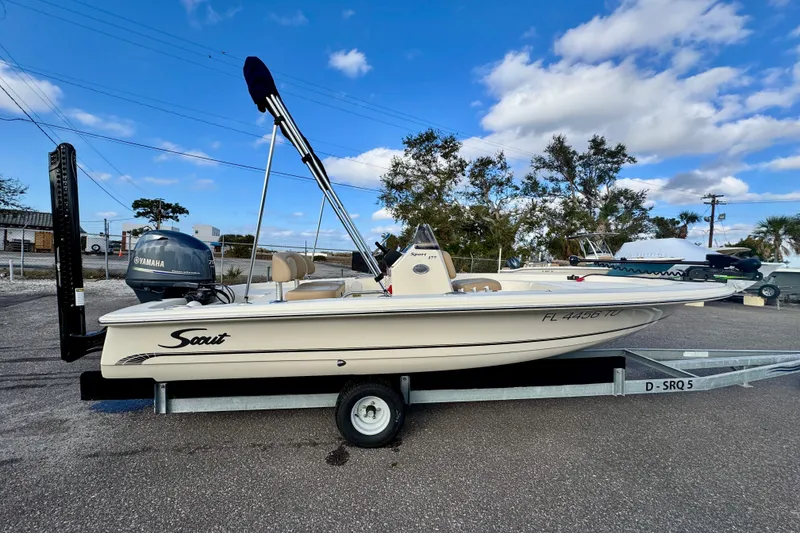 Slide: The Image of 2023 Scout 177 Sport boat on trailer, parked outdoors under blue sky. - 3
