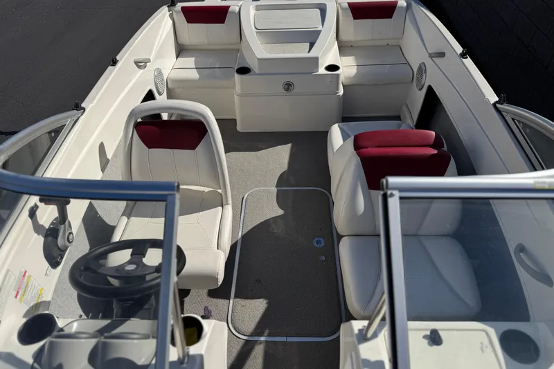 Slide: The Image of 2015 Bayliner 175 Bowrider interior with white and red seating, steering wheel, and dashboard. - 13