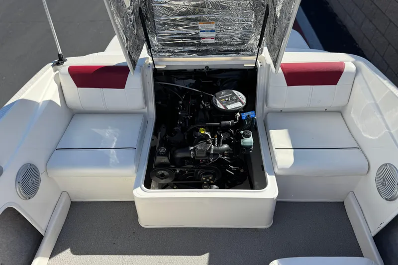 Slide: The Image of 2015 Bayliner 175 Bowrider engine compartment with open hatch, showcasing interior seating and engine. - 14