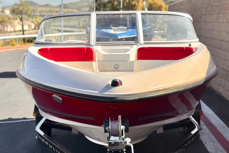 Slide: The Image of 2015 Bayliner 175 Bowrider boat on trailer, red and white exterior, parked outdoors. - 2