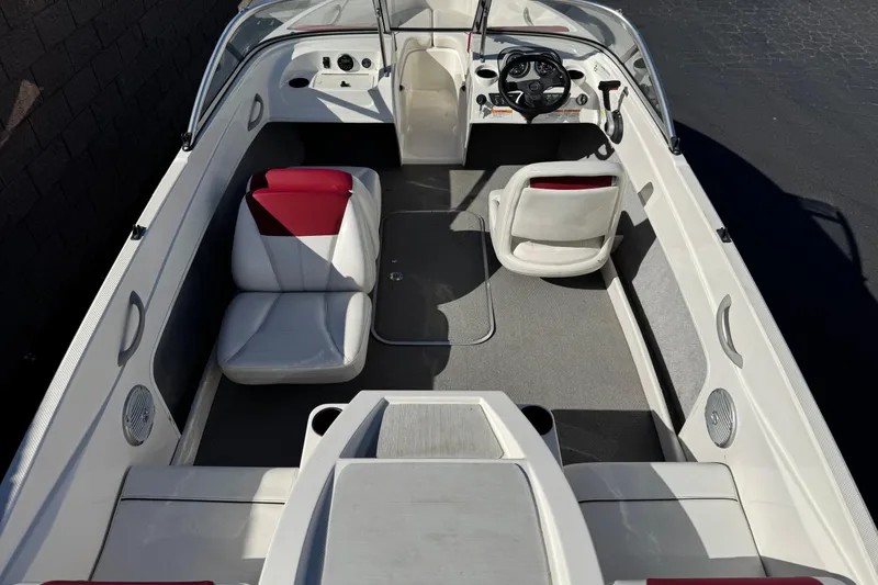 Slide: The Image of 2015 Bayliner 175 Bowrider interior with white and red seating, steering wheel, and dashboard. - 8