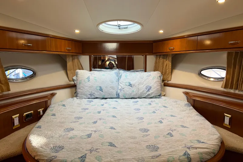 Slide: The Image of Luxurious 2006 Carver 39 Motor Yacht bedroom with elegant wood cabinetry and cozy bedding. - 18