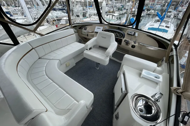 Slide: The Image of 2006 Carver 39 Motor Yacht interior with white seating, helm, and marina view. - 4