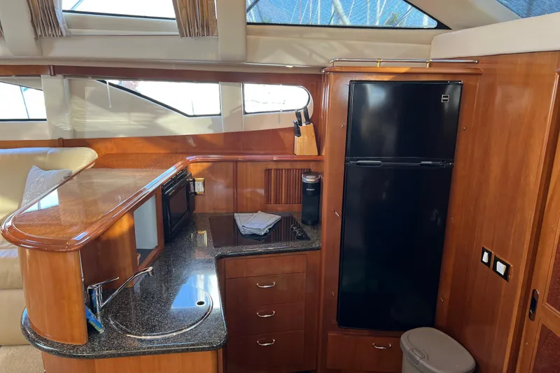 Slide: The Image of Luxurious kitchen interior of 2006 Carver 39 Motor Yacht with wood cabinetry and modern appliances. - 11