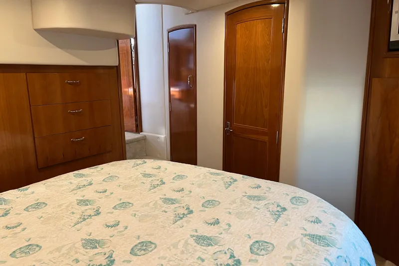Slide: The Image of Interior of 2006 Carver 39 Motor Yacht bedroom with wooden cabinets and patterned bedding. - 15