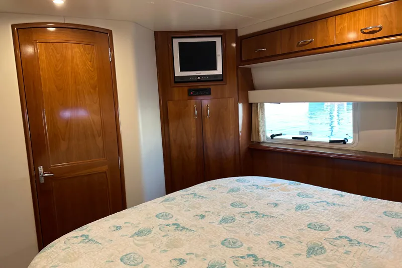 Slide: The Image of 2006 Carver 39 Motor Yacht bedroom with wood cabinetry, TV, and window view. - 16