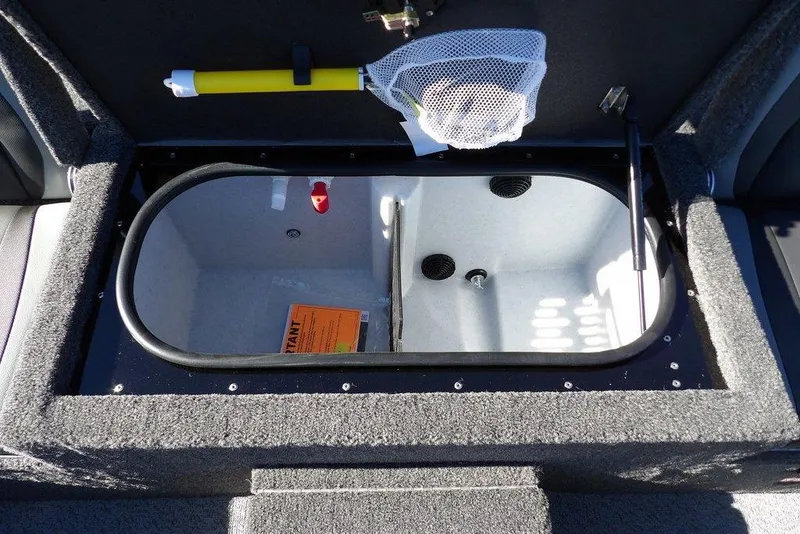 Slide: The Image of Open storage compartment in 2026 Lund 1875 Renegade boat, featuring fishing net and accessories. - 18