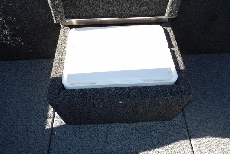 Slide: The Image of 2026 Lund 1875 Renegade boat storage compartment with white lid, carpeted interior. - 21