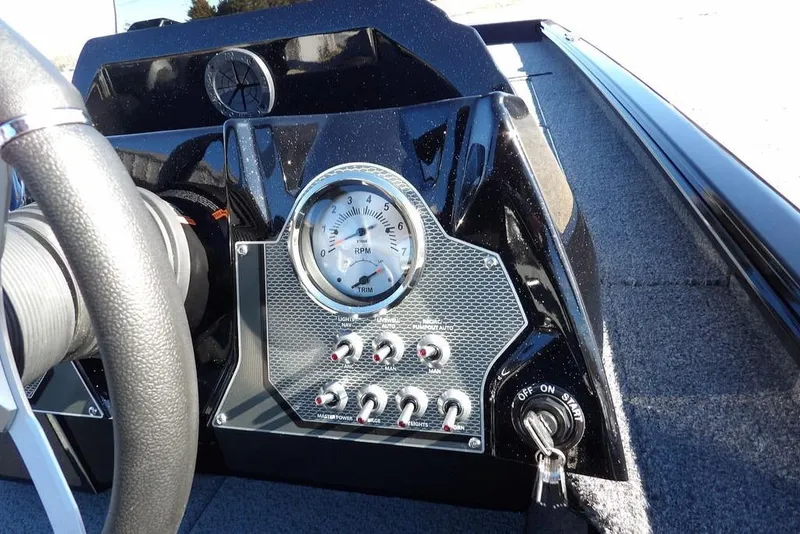 Slide: The Image of 2026 Lund 1875 Renegade boat dashboard with RPM gauge and control switches. - 26