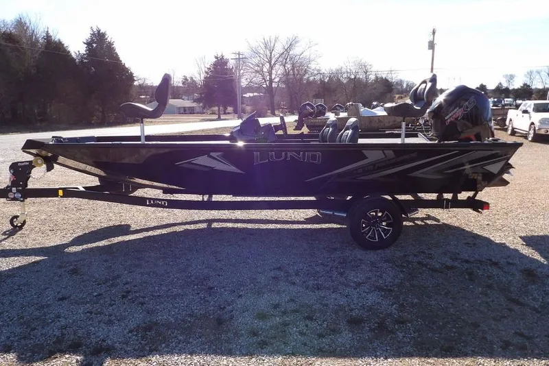 Slide: The Image of 2026 Lund 1875 Renegade fishing boat on trailer, parked outdoors. - 6