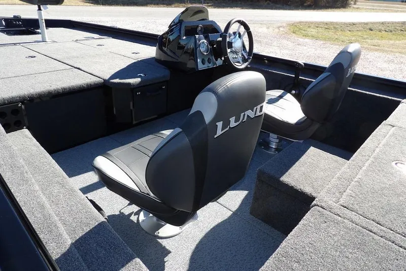 Slide: The Image of 2026 Lund 1875 Renegade boat interior with plush seating and modern dashboard. - 7