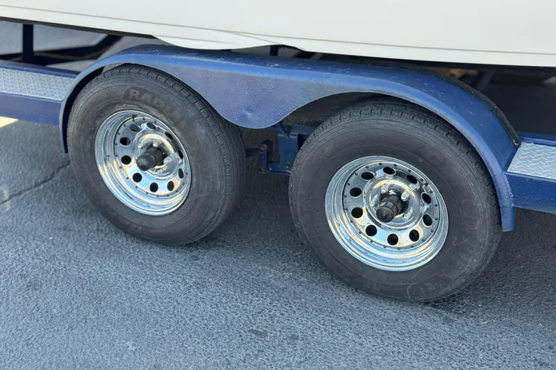 Slide: The Image of Trailer wheels of a 2008 Crownline 21 SS boat on a blue trailer. - 27