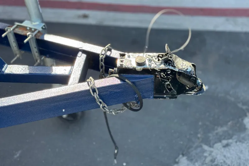 Slide: The Image of Trailer hitch of a 2008 Crownline 21 SS boat, featuring a blue frame and safety chains. - 28