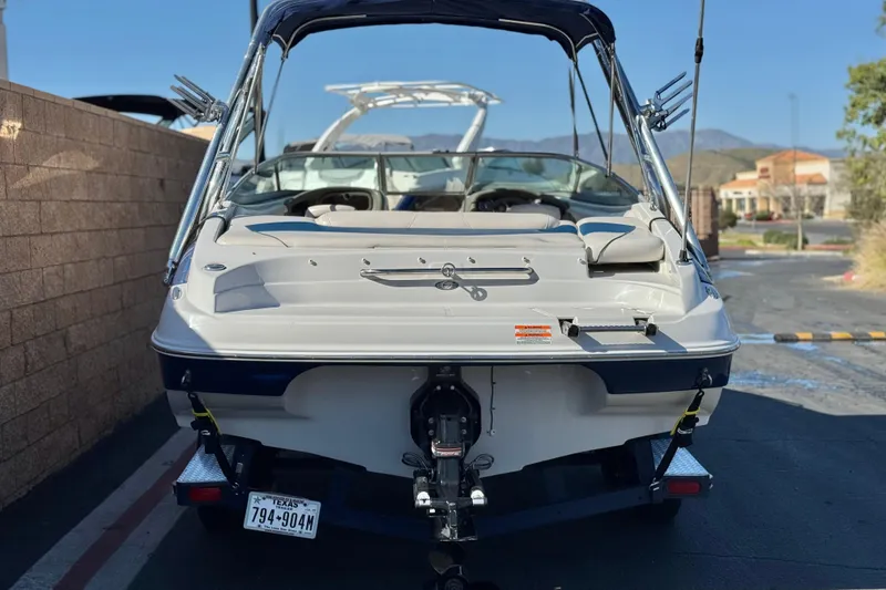 Slide: The Image of 2008 Crownline 21 SS boat, rear view, parked on a trailer in a sunny setting. - 4