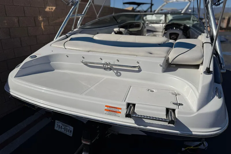 Slide: The Image of 2008 Crownline 21 SS boat with swim platform and seating, parked outdoors. - 6