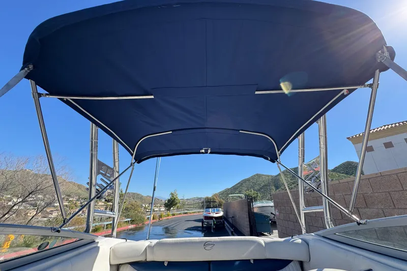 Slide: The Image of 2008 Crownline 21 SS boat with blue canopy, docked near scenic mountains. - 9
