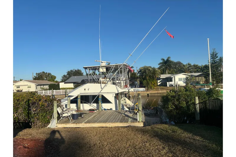 The Image of 1971 Bertram 46 Convertible boat docked in a residential canal setting. - 1