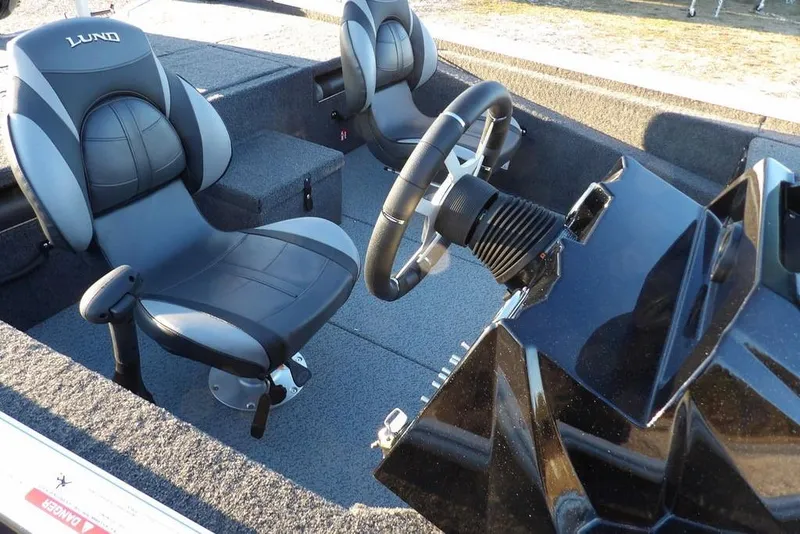 Slide: The Image of 2026 Lund 1875 Renegade boat interior with steering wheel and two seats. - 17