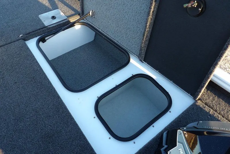 Slide: The Image of 2026 Lund 1875 Renegade boat storage compartments with open hatches, carpeted interior. - 37