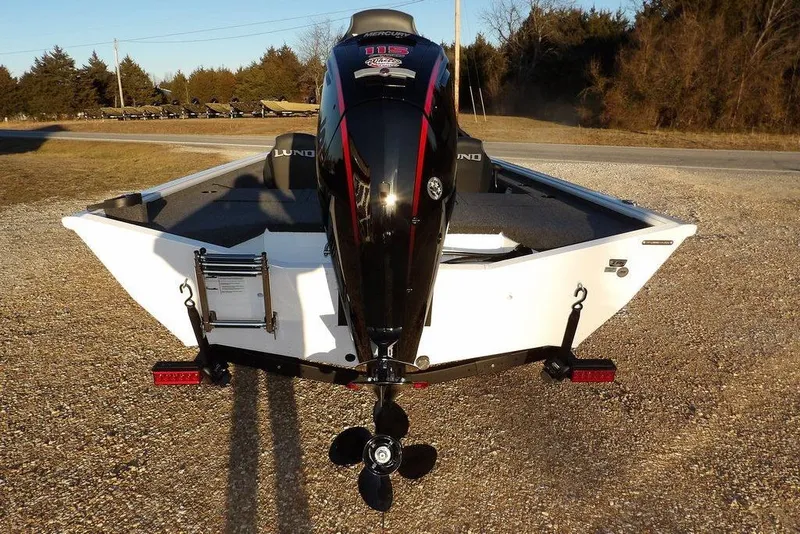 Slide: The Image of 2026 Lund 1875 Renegade boat with outboard motor, parked on gravel. - 4