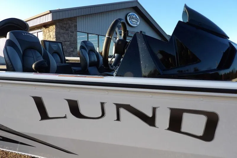 Slide: The Image of 2026 Lund 1875 Renegade boat with sleek design, parked near marine center. - 46