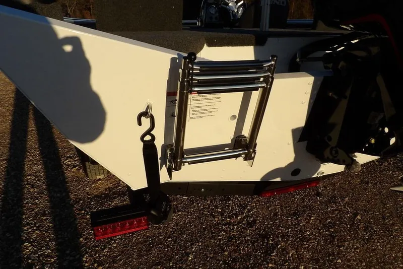 Slide: The Image of 2026 Lund 1875 Renegade boat ladder and trailer detail in sunlight. - 48