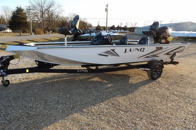 Slide: The Image of 2026 Lund 1875 Renegade fishing boat on trailer, parked outdoors. - 6