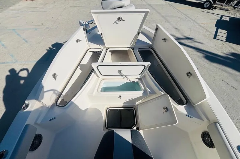 Slide: The Image of 2021 Ranger 2510 Bay boat with open storage compartments on deck. - 16