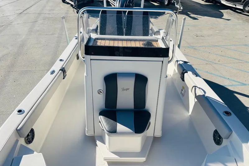 Slide: The Image of 2021 Ranger 2510 Bay boat interior with seating and console, docked outdoors. - 18