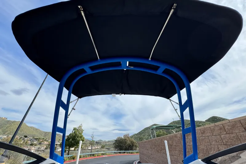 Slide: The Image of 2020 Yamaha AR210 boat with blue canopy, scenic mountain backdrop. - 10